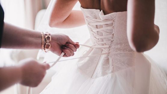 A bride trying on her new dress.